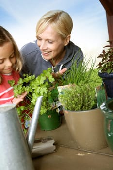 Mother and daughter in garden planting aromatic flowers
