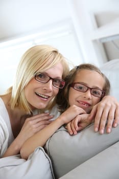 Mom and little girl sitting in sofa