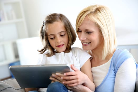 Mother and daughter playing with electronic tablet