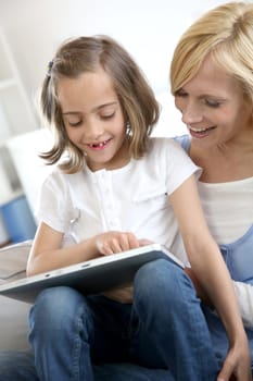Mother and daughter playing with electronic tablet