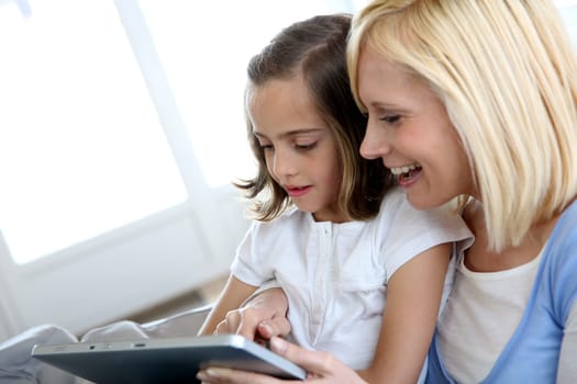 Mother and daughter playing with electronic tablet