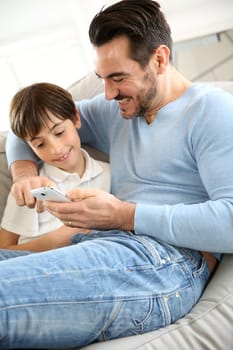 Little boy with dad playing with smartphone