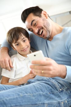 Little boy with dad playing with smartphone