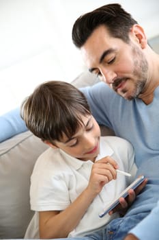 Little boy with dad playing with smartphone