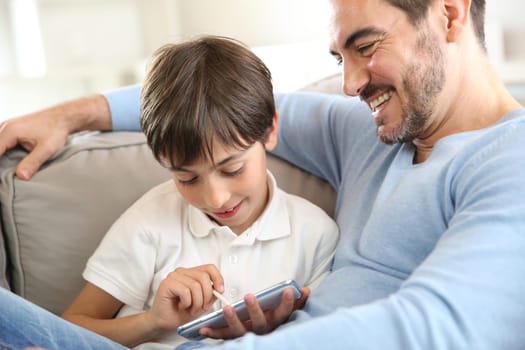 Little boy with dad playing with smartphone