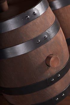 two old wooden barrels with wooden plugs on a dark wood background