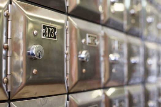 Many po boxes at the post office. The mail boxes are lined up in rows and columns. Selective focus