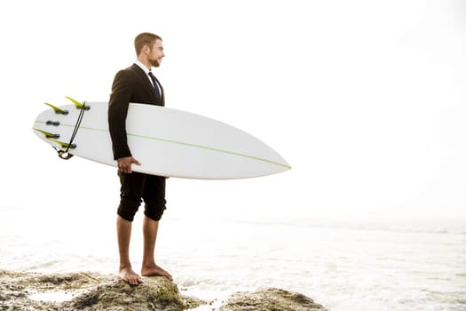 Businessman holding a chalkboard and is surfboard. Concept about a man starting a new life.