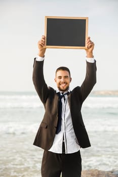Businessman holding a chalkboard and is surfboard. Concept about a man starting a new life.