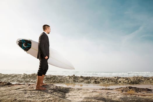 A Businessman holding is surfboard after a long day of work