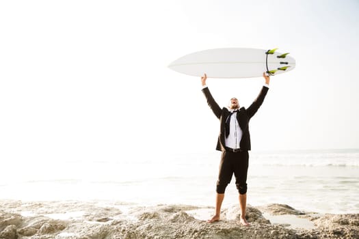 Businessman holding a chalkboard and is surfboard. Concept about a man starting a new life.