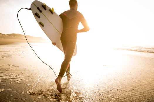 A surfer with his surfboard at the beach