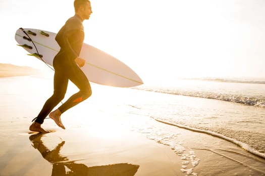 A surfer with his surfboard at the beach