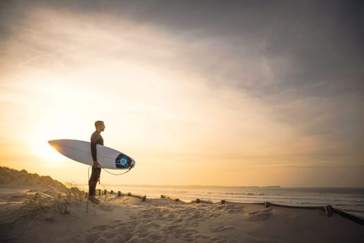 A surfer with his surfboard at the beach