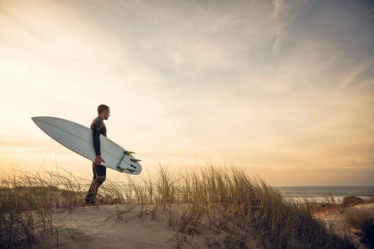 A surfer with his surfboard at the beach