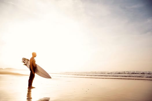 A surfer with his surfboard at the beach