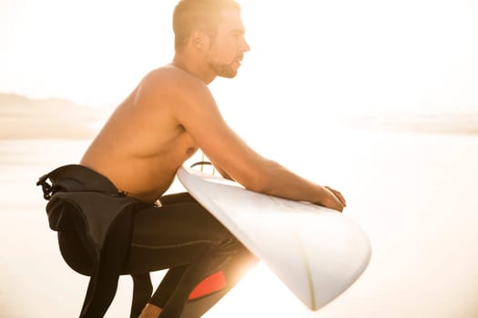 A surfer with his surfboard at the beach