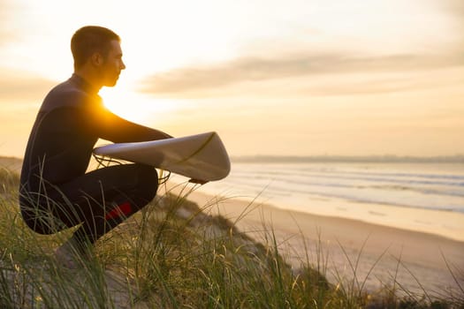 A surfer with his surfboard at the beach