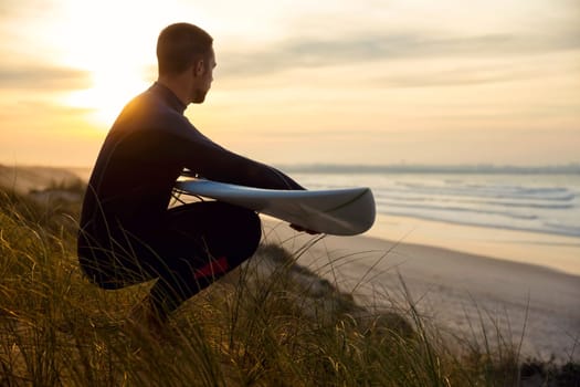 A surfer with his surfboard at the beach