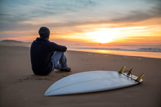 A surfer with his surfboard at the beach