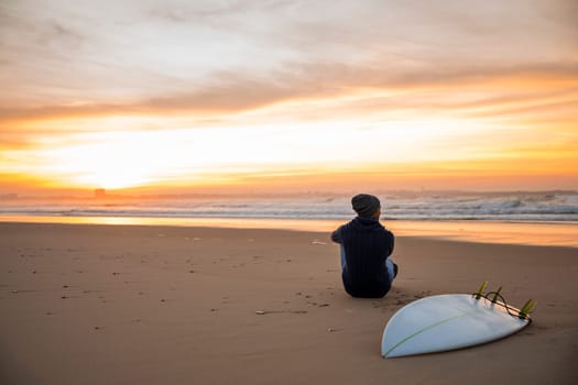 A surfer with his surfboard at the beach