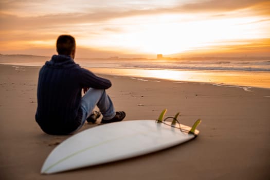 A surfer with his surfboard at the beach