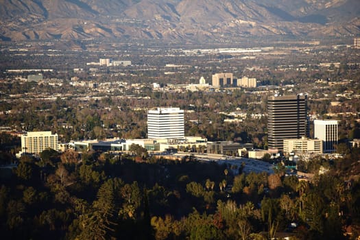 Various skyscrapers and shopping malls surrounded by parks and mountains in Los Angeles.