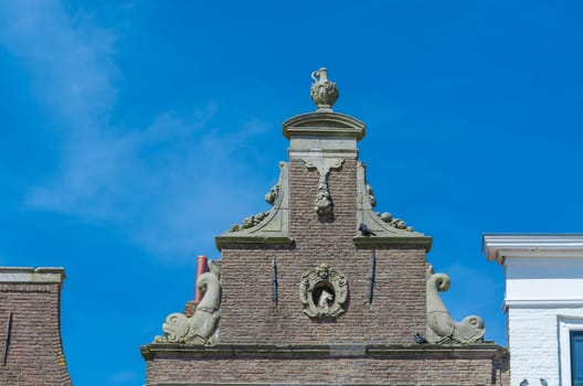 Antique house facade,pediment from a villa in front of blue sky..