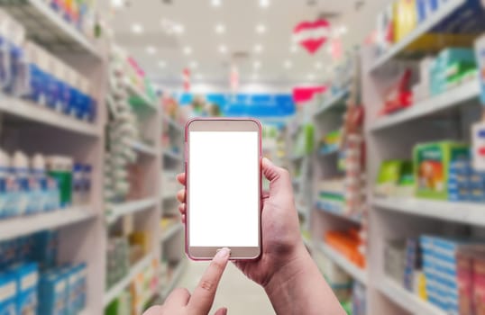 The women using smartphone in pharmacy on blurred background
