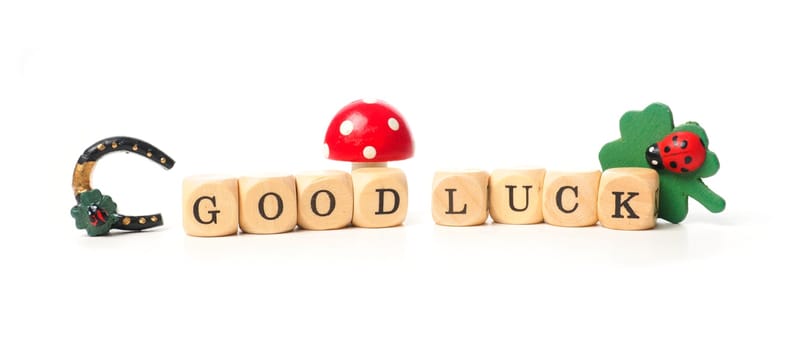 Wooden dices with the words Good luck on a white background