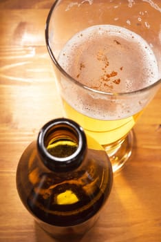 Close-up of a beer glass with beer bottle on the table