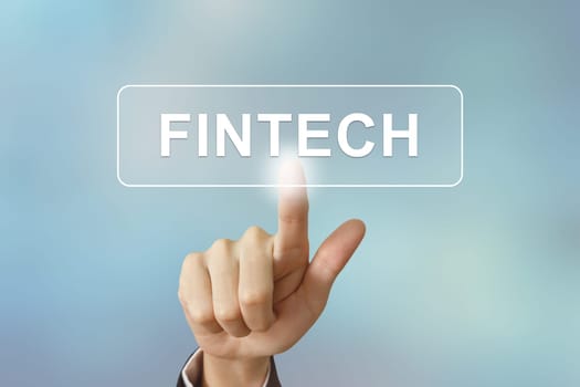 business hand pushing fintech or Financial technology button on blurred background