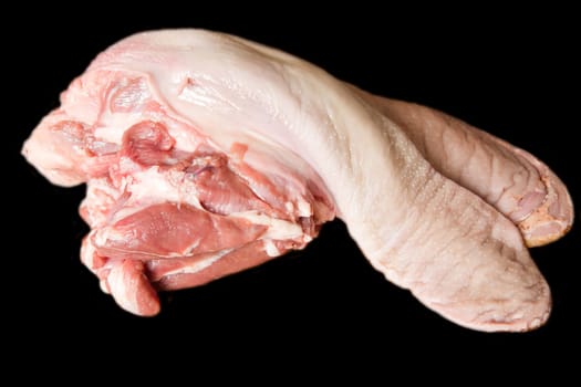 Photo of raw pork tongue on black background