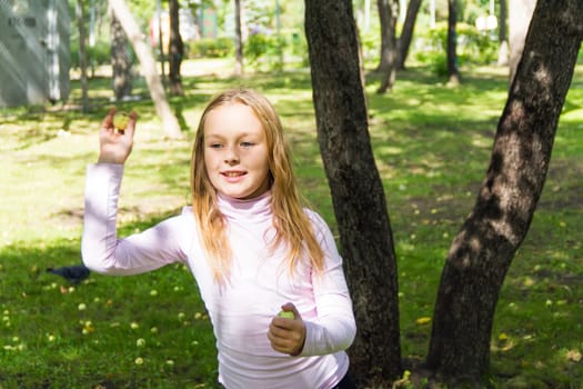 Photo of cute girl with apples in summer