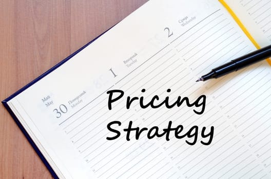 Pricing strategy text concept write on notebook with pen