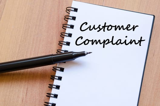 Customer complaint text concept write on notebook with pen