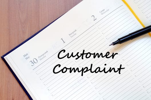 Customer complaint text concept write on notebook with pen