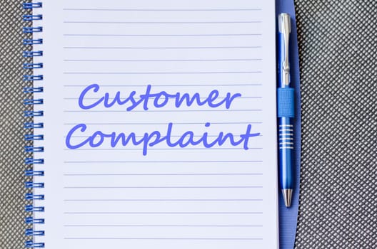 Customer complaint text concept write on notebook with pen
