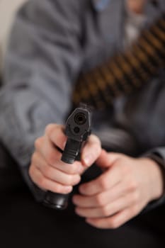 Close up Hand of a Boy Holding a Gun Pointing at the Camera and Ready to Shoot.