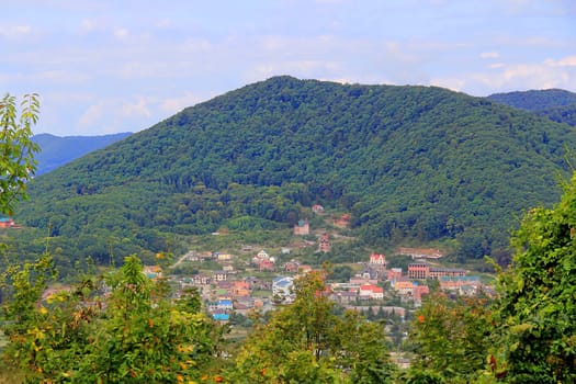 Summer landscape with Caucasus mountains and small town