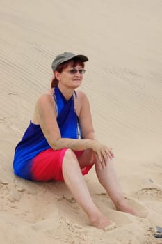 Woman sits in the sand