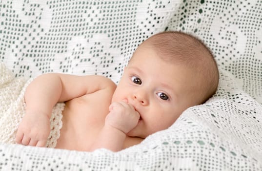 Newborn baby boy naked on white blanket