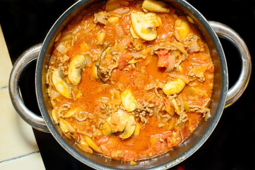 cooking the sauce for lasagne in a pan