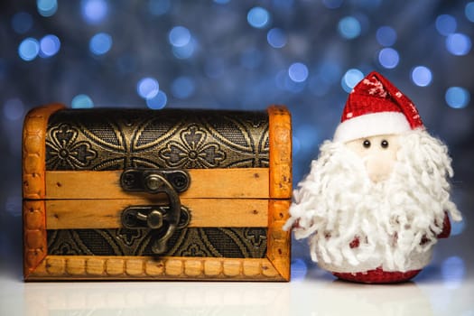 Santa Claus or Father Frost and wooden chest on christmas lights background