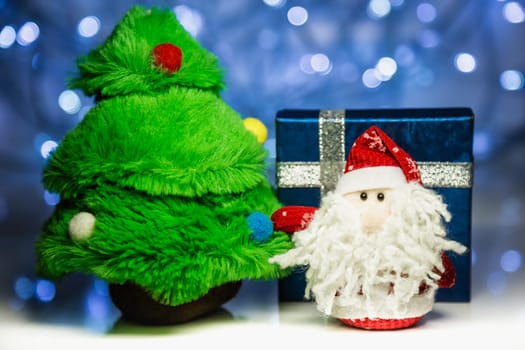 Santa Claus or Father Frost with fir tree and gift box on christmas lights background