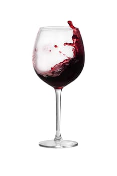 Red wine is splashing out of a wine glass