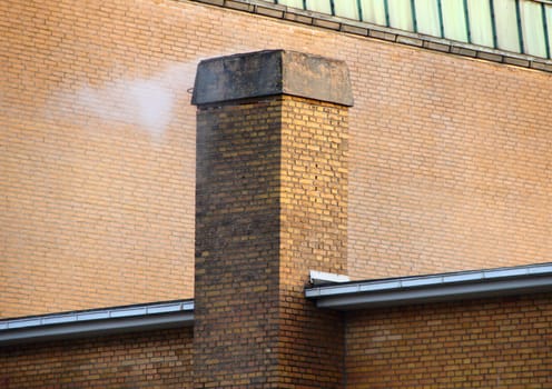 Smoking Chimney on Yellow Brick Tile Building with Shadow