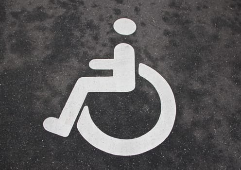 Isolated White Handicap Disabled Sign on Black Asphalt