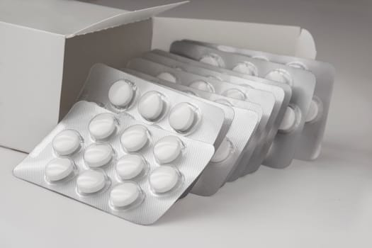 Colse Up View, Multiple Loafs of Tablets Getting Out Form the Box over gray background with shadow.