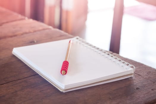 Work station with notebook and pencil with vintage filter, stock photo